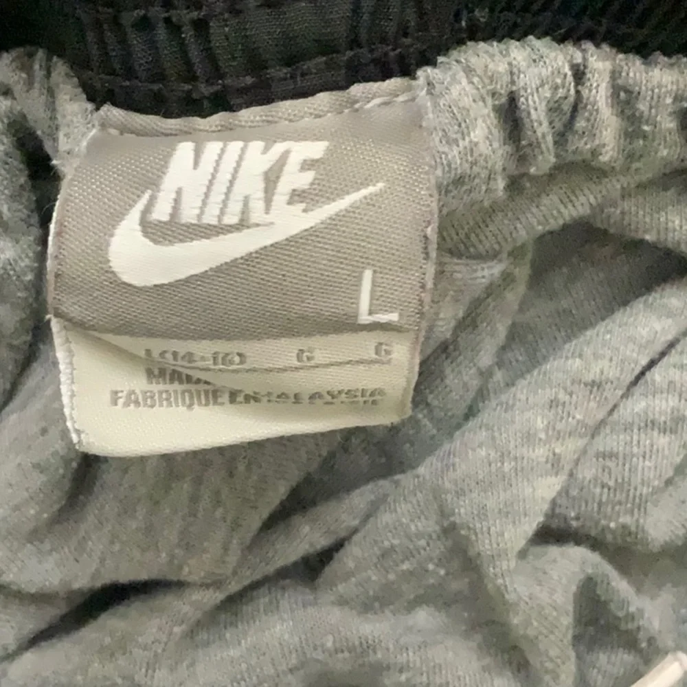 NIKE black athletic sweatpants. Side pockets. Zipper opening. Elastic waist. SZL
